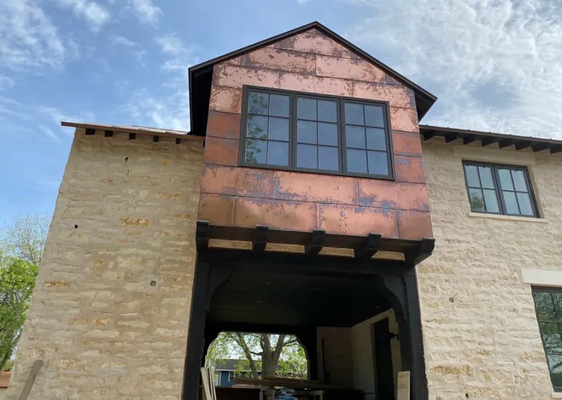 Copper metal panel facade on a stone building for Skylight Installation in Ledyard